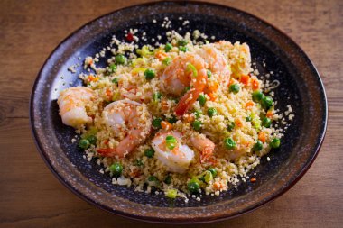 Karides kuskus, yeşil bezelye, pırasa ve havuç ile. Yatay