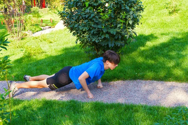 Genç adam Push ups egzersiz Park yapmak