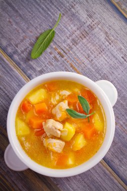 Tavuk, butternut squash, elma, zencefil ve adaçayı ahşap masa üzerinde beyaz kapta güveç. Balkabağı çorbası tavuk. Tepegöz, dikey