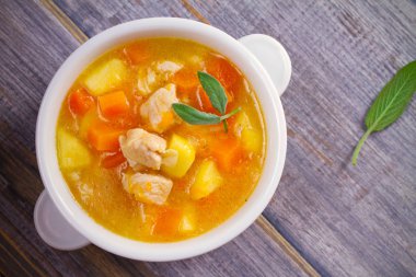 Tavuk, butternut squash, elma, zencefil ve adaçayı ahşap masa üzerinde beyaz kapta güveç. Balkabağı çorbası tavuk. Tepegöz, yatay