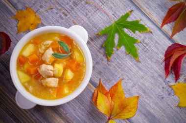 Tavuk, butternut squash, elma, zencefil ve adaçayı ahşap masa üzerinde beyaz kapta güveç. Balkabağı çorbası tavuk. Tepegöz, yatay