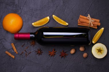 Bir şişe kırmızı şarap ile baharat, narenciye ve elma için mulled şarap sıcak içecek. üstten görünüm, yatay