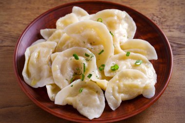 Hamur köfteleri, ahşap masada patates püresi ile dolu. Varenyky, vareniki, pierogi, pirohy - dolgulu börek. Vejetaryen yemeği. yatay