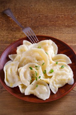 Köfte, patates püresi plaka üzerinde ahşap masa dolu. Varenyky, vareniki, pierogi, pyrohy - köfte dolgu ile. Vejetaryen yemek. dikey