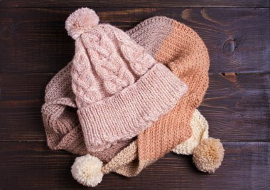 Örgü şapka ve atkı, kış konsepti. Kadınların kış sıcak aksesuar ahşap arka plan üzerinde. Düz lay, yukarıdan, üst görünümü