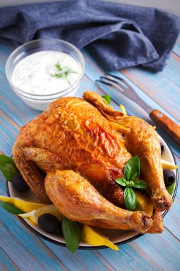 Mavi ahşap zemin üzerine yoğurt soslu tavuk. dikey