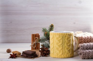 Sıcak kış içki, tanımlama bilgileri, tarçın, kış dekorasyonları ile örme sarı Kupası. Sıcak ve rahat bir atmosfer soğuk sezon sırasında. kopya alanı