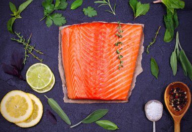 Limon, kireç ve siyah arka plan üzerinde otlar taze çiğ Somon balık. Flatlay gıda ayarı. Yukarıdan görüntülemek, top 