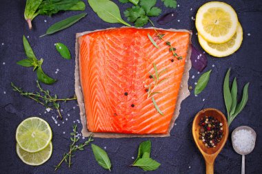 Limon, kireç ve siyah arka plan üzerinde otlar taze çiğ Somon balık. Flatlay gıda ayarı. Yukarıdan görüntülemek, top 