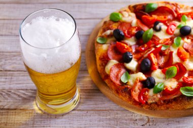 Bardak bira ve pizza ahşap masa üzerinde. Bira ve gıda kavramı. Ale.