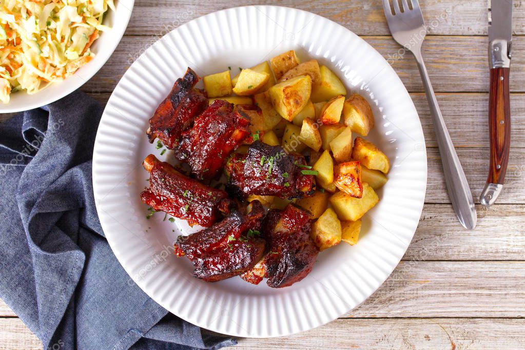 Grilled pork spare ribs with fries. Roasted sliced barbecue ribs. View from above, top studio shot, copy space 