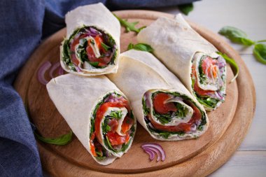 Somon füme, krem peynir, ıspanak ve roka tamamladı. Balık burrito. Yatay