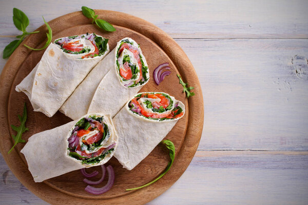 Smoked Salmon, Cream Cheese, Spinach and Arugula Wraps. Fish Burritos. overhead, horizontal