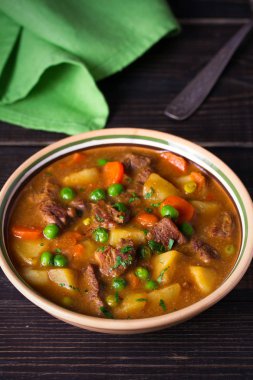 Patates, havuç ve bezelye kase ahşap masa üzerinde ev yapımı İrlanda sığır eti güveç. dikey