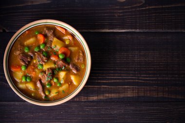 Patates, havuç ve bezelye kase ahşap masa üzerinde ev yapımı İrlanda sığır eti güveç. Genel gider, yatay, kopya alanı