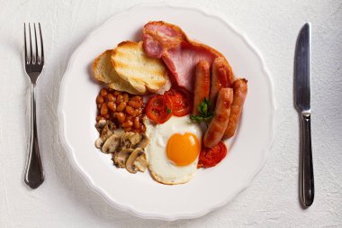 Tam İngilizce veya İrlandalı kahvaltı sosis, pastırma, yumurta, domates, mantar ve fasulye. Sabah besleyici ve sağlıklı yemek. Yukarıda görmek, en iyi stüdyo vurdu
