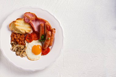 Tam İngilizce veya İrlandalı kahvaltı sosis, pastırma, yumurta, domates, mantar ve fasulye. Sabah besleyici ve sağlıklı yemek. Yukarıda görmek, en iyi stüdyo vurdu