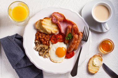 Tam İngilizce veya İrlandalı kahvaltı sosis, pastırma, yumurta, domates, mantar ve fasulye. Sabah besleyici ve sağlıklı yemek. Yukarıda görmek, en iyi stüdyo vurdu