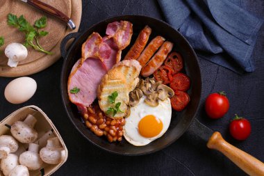 İngilizce veya İrlandalı kahvaltı sosis, pastırma, yumurta, domates, mantar ve fasulye tava üzerinde. Sabah besleyici ve sağlıklı yemek. Yukarıda görmek, en iyi stüdyo vurdu