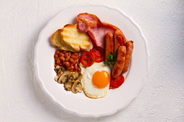 İngilizce veya İrlandalı kahvaltı sosis, pastırma, yumurta, domates, mantar, beyaz plaka kızartır ve kuru fasulye. Yatay, ek yükü