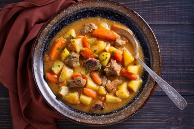 Ahşap masada kase sebze ile ev yapımı sığır güveç