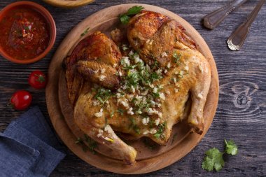 Ahşap tepsi üzerinde sarımsak ile kavrulmuş tavuk. Yukarıdan görünüm, üst