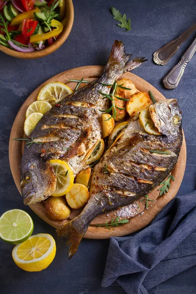 Kavrulmuş balık ve patates, ahşap tepside servis edilir. genel, dikey - görüntü