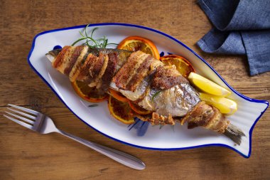 Portakal ve biberiye ile ızgara pastırma sarılı balık, limon ile servis - Resim