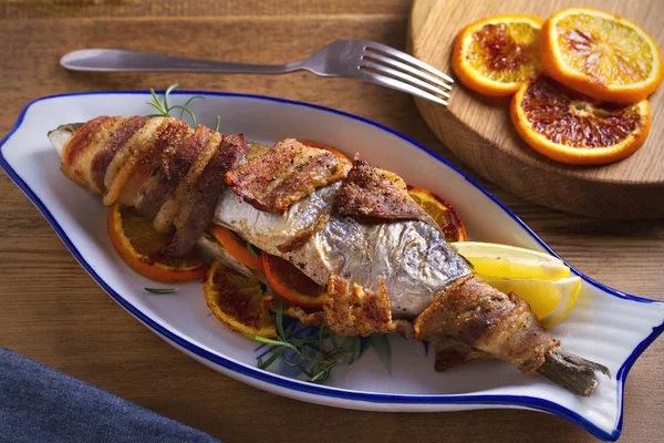 烤培根包装鱼与橙子和迷迭香 与柠檬服务 — 图库照片