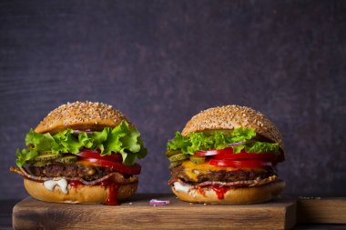 Ahşap doğrama tahtası üzerinde pastırma ile lezzetli ev yapımı sığır burger. yatay, kopyalama alanı, gıda arka plan