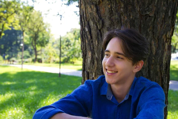 Jovem Sentado Grama Lado Árvore Parque — Fotografia de Stock