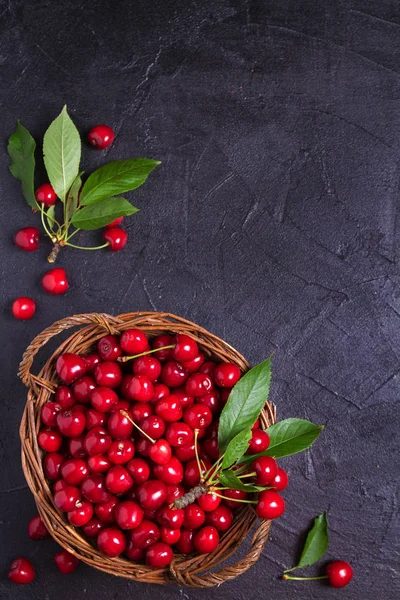 Fresh cherries in basket on black background. Fresh ripe sweet cherries