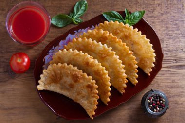 Chebureki - et ve soğan ile tavada kızarmış pasta. Kızarmış hamur yemeği. Yukarıdan görüntüle, en iyi stüdyo çekimi