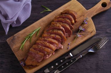 Dilimlenmiş ördek göğsü, lavanta bal ve biberiye servis tahtası