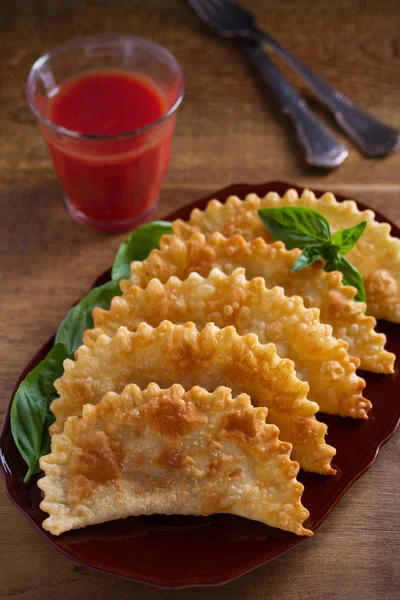 Chebureki - pan fried pies with meat and onions on plate. Fried-dough food. vertical - image