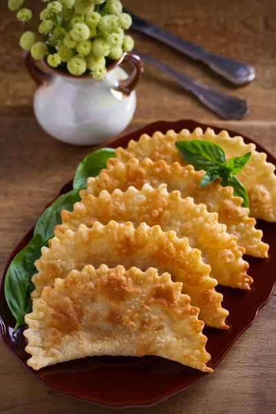 Chebureki - pan fried pies with meat and onions on plate. Fried-dough food. vertical - image
