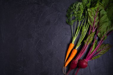 Havuç ve pancar koyu arka planda. Yaz sebze arka plan. Düzen, düz döşeme, kopyalama alanı