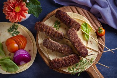 Pide, sebze ve yoğurt soslu servis tahtasında kuzu kebaplar. Yukarıdan görüntüle, en iyi stüdyo çekimi