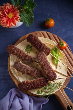 Pide, sebze ve yoğurt soslu servis tahtasında kuzu kebaplar. Yukarıdan görüntüle, en iyi stüdyo çekimi