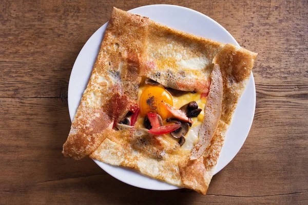 Krep, peynir, yumurta, domates ve mantar ile ince krep. Yukarıdan görüntüle, en iyi stüdyo çekimi