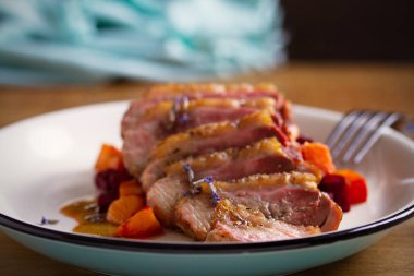 Tabakta tatlı patates ve pancar ile dilimlenmiş ördek göğüs filetosu