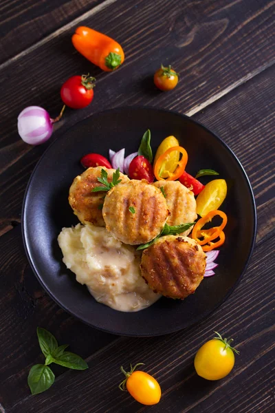 Fish cakes with mashed potatoes and vegetables. Fish patties. Fried cutlets of minced fish. View from above, top studio shot