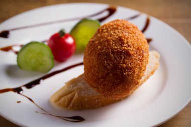 Tavuk Kiev ve beyaz plaka, ahşap arka plan üzerinde sebze. Ekmekli tavuk göğsü otlar ve tereyağı ile doldurulmuş