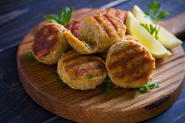 Limon lu balık kekleri ve otlar. Tahta tahtada balık köftesi