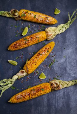 Parmesan peyniri, kırmızı biber, tuz, kişniş ve kireç ile ızgara tatlı mısır koçanı üst görünümü