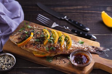 Portakal zencefil balık, susam ve kişniş serpilir. Soya portakal sosu