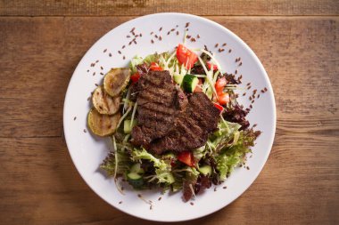 Sığır salatası: domates, salatalık, kabak, marul ve lahana ile ızgara sığır biftek, keten tohumu serpilir. Genel, yatay görüntü
