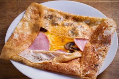 Krep, jambon, peynir, yumurta ve mantar ile ince krep. Beyaz tabakta dolgulu krep