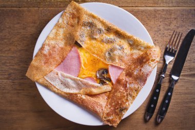 Krep, jambon, peynir, yumurta ve mantar ile ince krep. Beyaz tabakta dolgulu krep