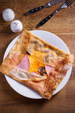 Krep, jambon, peynir, yumurta ve mantar ile ince krep. Beyaz tabakta dolgulu krep